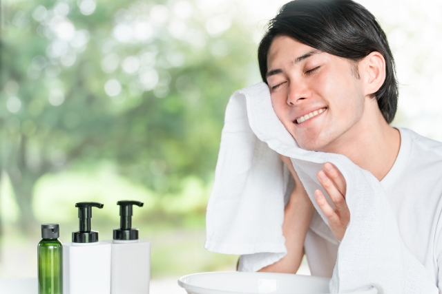 洗顔後が終わりタオルで顔を拭く男性